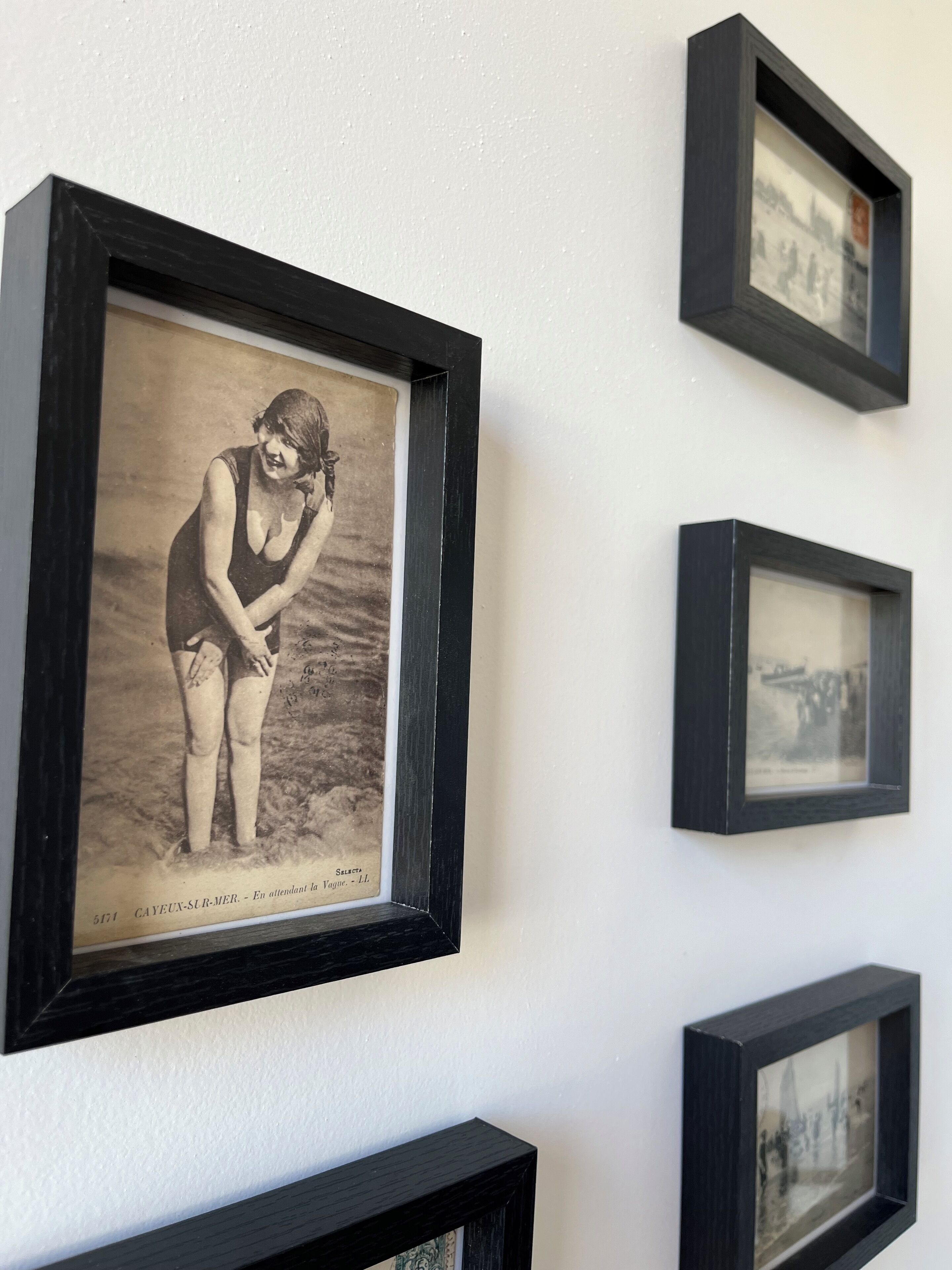 A wall with multiple black-framed photographs.