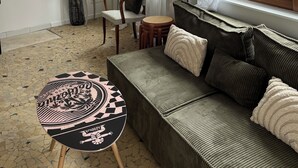 A living room with a sofa, a small round table, a chair, and a vase with sunflowers. - Cayeux sur Mer. Family home 2 steps from the sea! (Cayeux-sur-Mer)