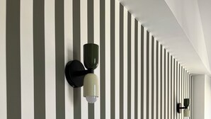 A room with a striped wall, two wall-mounted light fixtures, a bed with white bedding, and a window. - Cayeux sur Mer. Family home 2 steps from the sea! (Cayeux-sur-Mer)