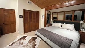 A bedroom with a large bed, wooden wardrobe, and a cowhide rug. - 4-bedroom family home in charming Sun Valley close to Baldy and trails! (Sun Valley)