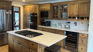 A modern kitchen with wooden cabinets, stainless steel appliances, and a central island. - 4-bedroom family home in charming Sun Valley close to Baldy and trails! (Sun Valley)