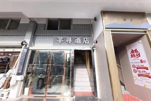 A hotel entrance with a glass door, a staircase leading to the entrance, and a sign above the door. - Aisong Hotel Shanghai (Shanghai)