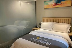 Ein Hotelzimmer mit einem Bett, einem Nachttisch und einem Bild an der Wand.