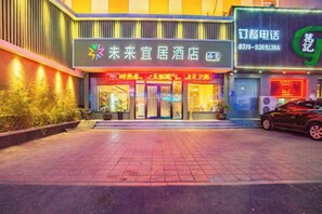 A hotel entrance with a signboard, a reception desk, and a car parked outside. - Future Yiju Shanghui Hotel (Zhengzhou Manhadun Yanzhuang Metro Station) (Zhengzhou)