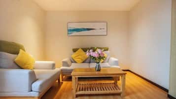 A modern living room with a sofa, a coffee table, and a painting on the wall.