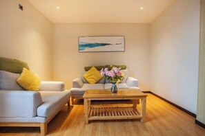 A modern living room with a sofa, a coffee table, and a painting on the wall.