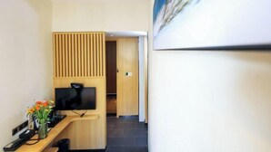 Een receptiebalie met een flatscreen televisie, een vaas met bloemen en een wand van hout.
