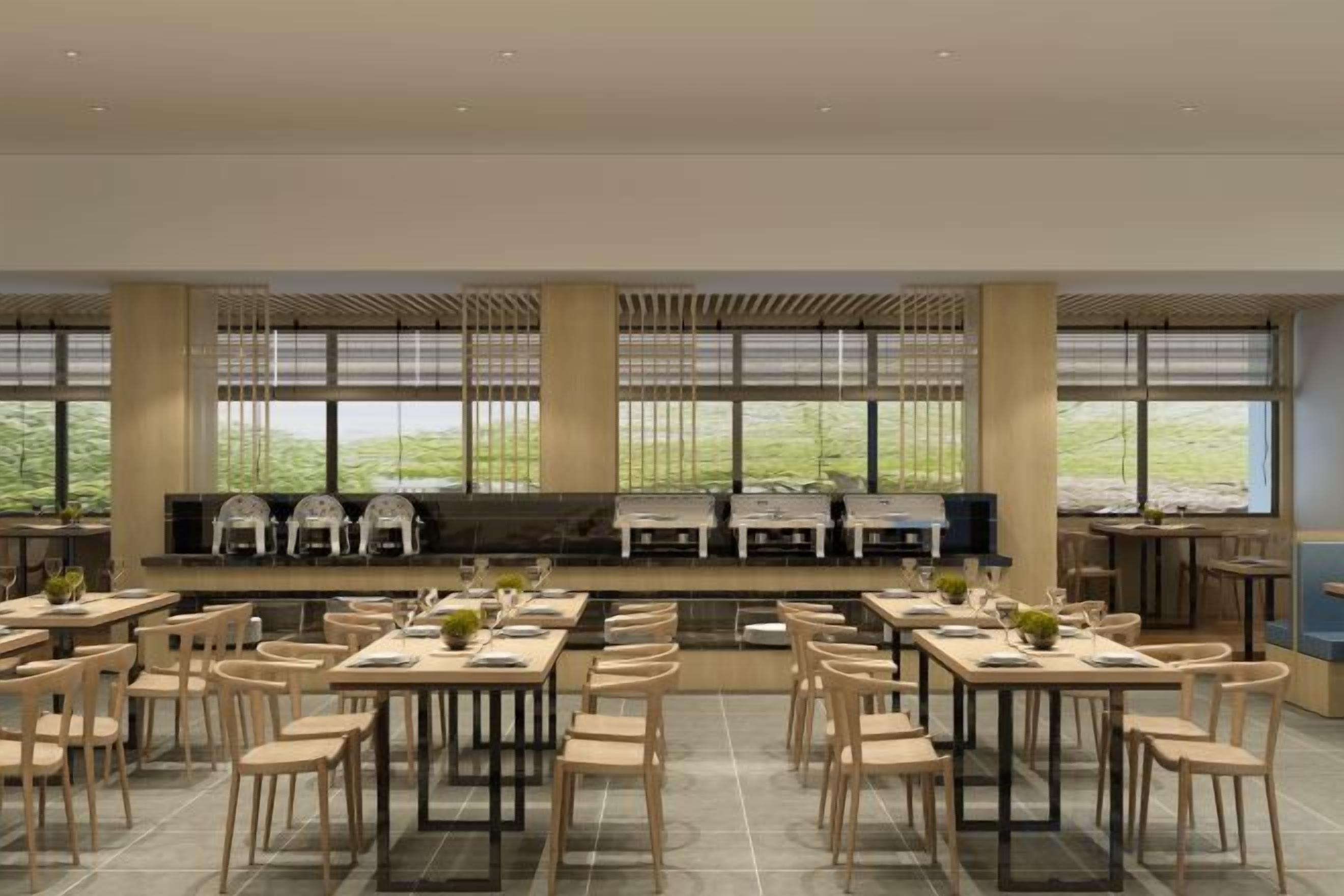 Un vaste espace dédié à la salle à manger, avec de nombreuses tables et chaises, de grandes fenêtres et une vue sur l’extérieur.