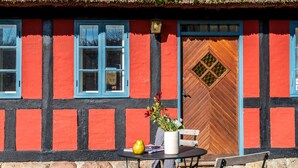 Un bâtiment traditionnel à colombages, doté d’une porte en bois et d’une fenêtre avec un cadre bleu.