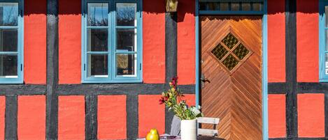 A traditional half-timbered building with a wooden door and a window with a blue frame.