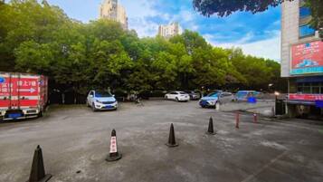 A parking lot with several cars, a red truck, and traffic cones.