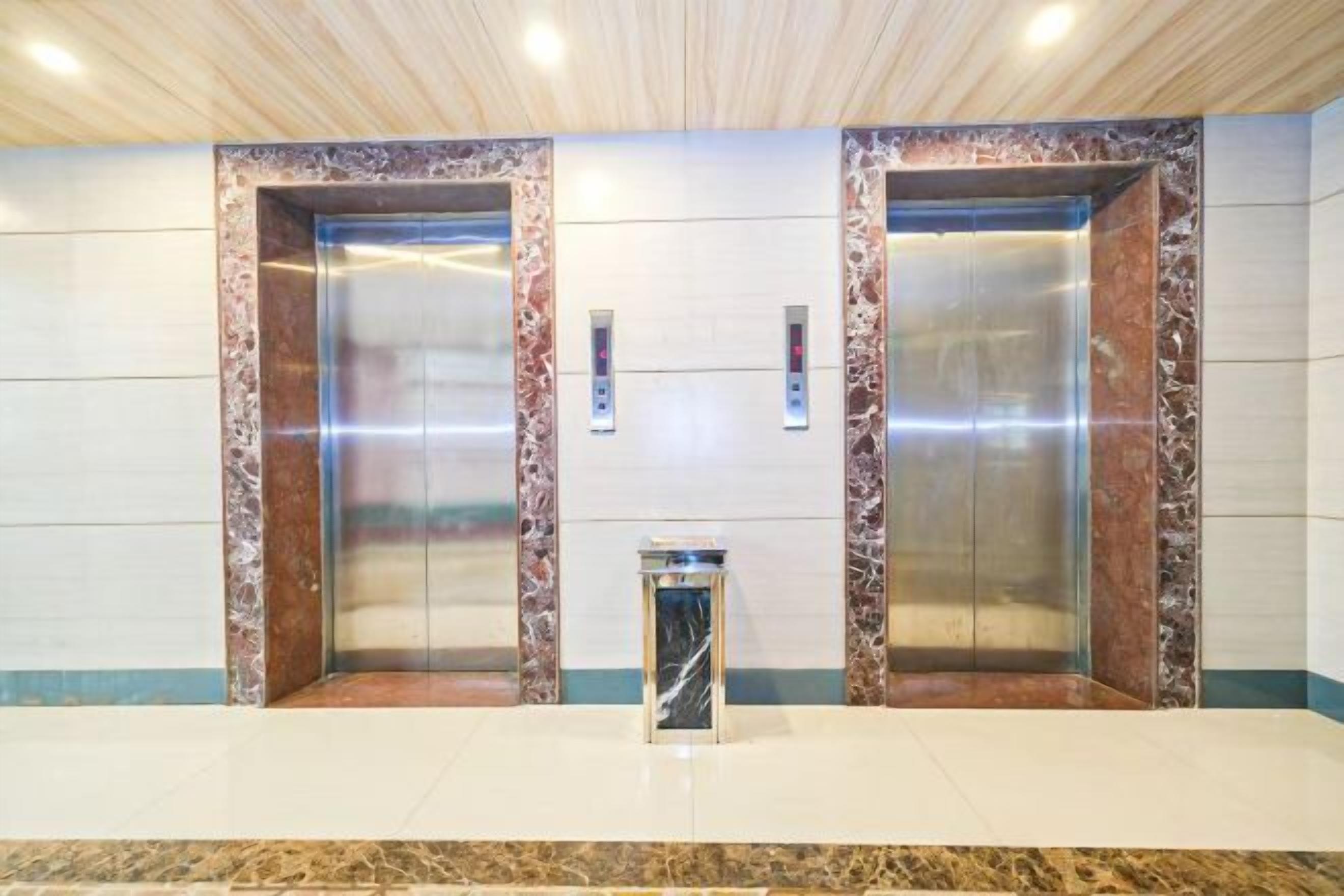 A modern elevator with marble accents and a digital display panel.