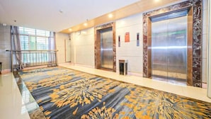 A modern elevator area with marble walls and a patterned carpet. - Anxin Intercity Hotel (Quanzhou Quangang) (Quanzhou)