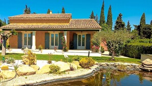 A two-story house with a tiled roof, a front porch, and a small pond. - Luxurious home in Sarrians (Sarrians)