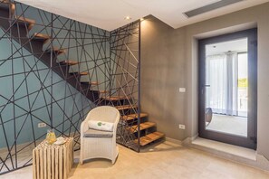 Step up to a stylish space with a geometric staircase, featuring a cozy reading nook and a seamless transition to the outdoors.