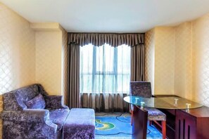 A hotel room with a sofa, a glass-top table, and a patterned carpet. - Yueyou Boutique Hotel (Chongqing Yuxi Square Branch) (Chongqing)