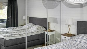 A modern bedroom with a bed, bedside tables, and a mirror. - Gorgeous home in Värmdö with sauna (Värmdö)