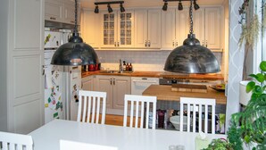 A kitchen with white cabinets, a wooden countertop, and two pendant lights. - Gorgeous home in Värmdö with sauna (Värmdö)