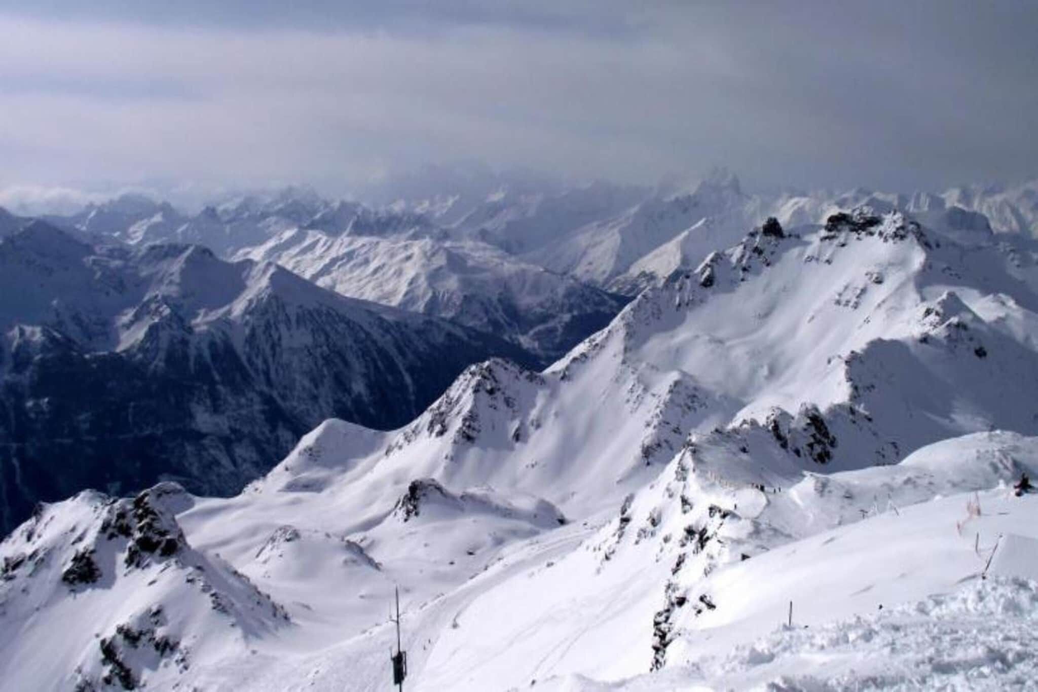Une chaîne de montagnes enneigée, aux pics escarpés, sous un ciel dégagé.