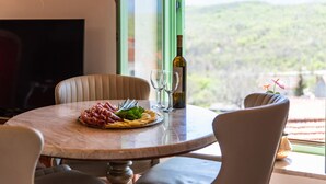 Una mesa de comedor con una botella de vino, dos copas y un plato de comida.