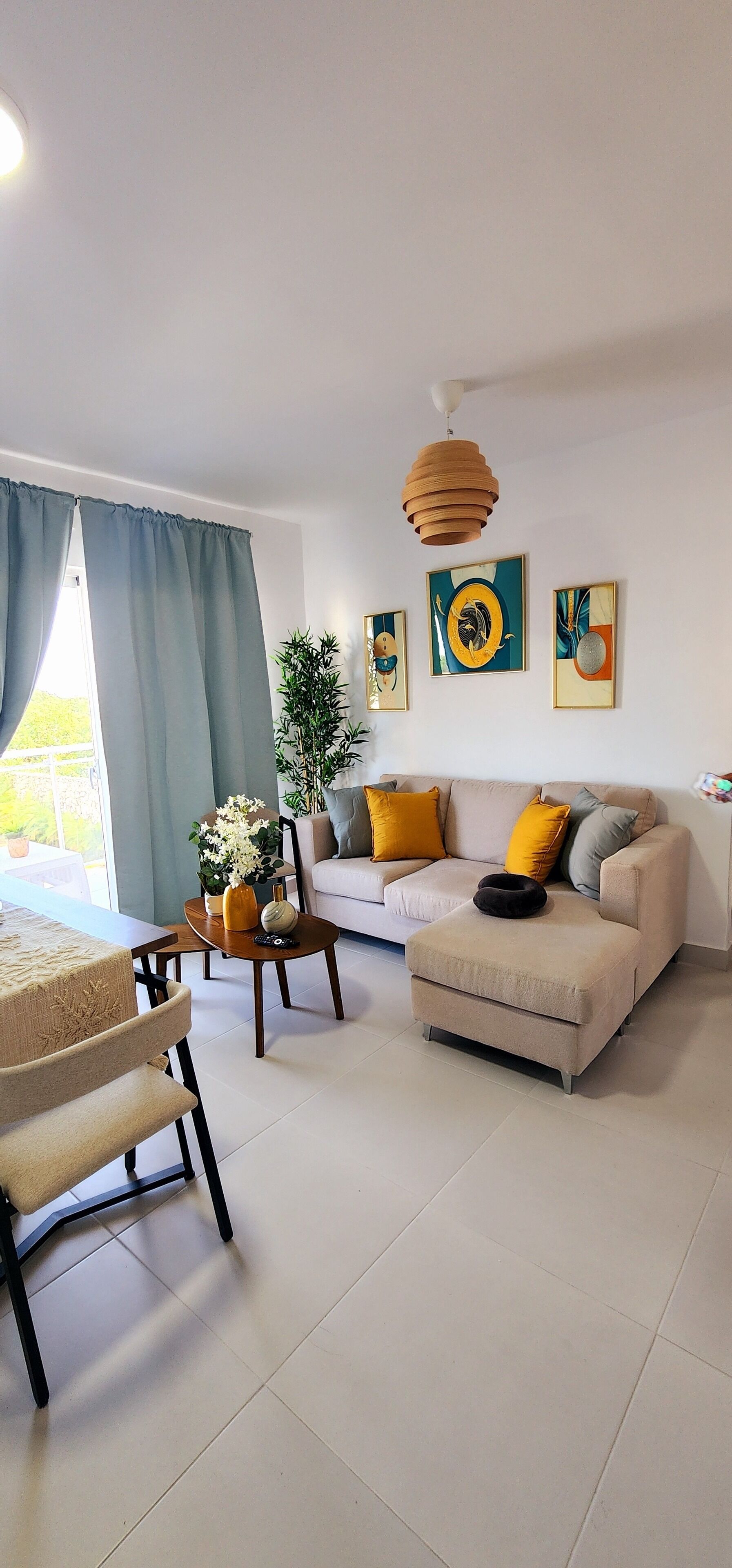 A modern living room with a sofa, coffee table, and dining area.