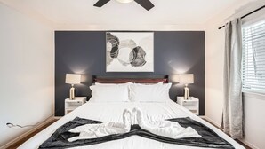 A bedroom with a bed, two bedside tables, a ceiling fan, and a window with curtains. - Comfy King Suite Getaway | Sleeps 4 | Pool, Prkg (Austin)