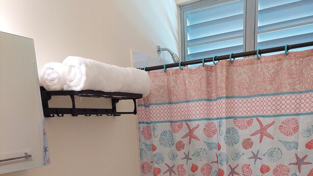 A bathroom with a toilet, sink, and a shower curtain with a sea-themed pattern. - Charming villa in enchanting Cabo Rojo with AC, WiFi. Near a beautiful beach (Cabo Rojo)