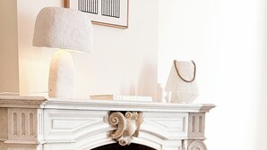 A fireplace with a brick interior, surrounded by potted plants and decorative items.
