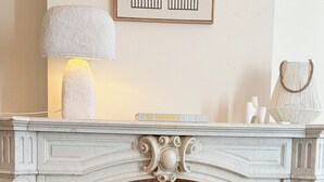 A fireplace with decorative elements, a lamp, and a vase with flowers.