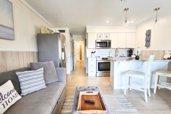 A modern kitchen with white cabinets, a microwave, and a built-in oven.
