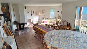 Een gezellige woonkamer met een open haard, een eethoek en een groot bed.