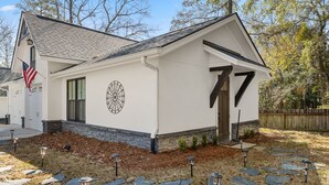 A modern house with a white exterior, a garage, and a front yard with stone steps and solar lights.