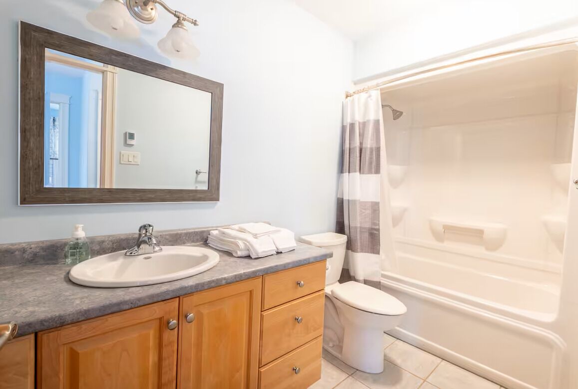 Une salle de bain avec un lavabo, un miroir et une douche.