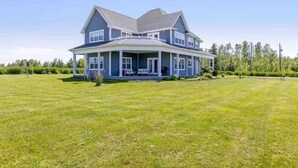 A two-story house with a large front porch and a spacious lawn. - The Perfect Brule Shore Getaway (Brule Shore)