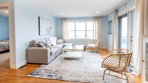 A modern living room with a sofa, coffee table, and wicker chairs. - The Perfect Brule Shore Getaway (Brule Shore)