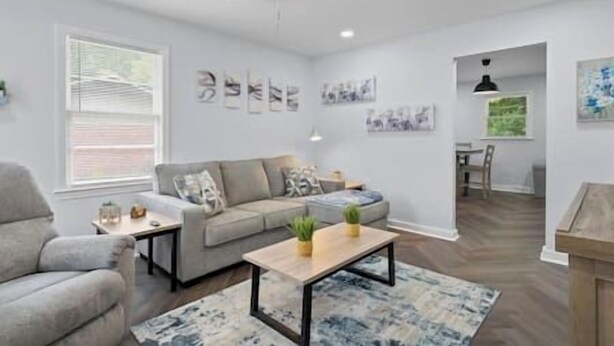 A modern living room with a grey sofa, a coffee table, and a ceiling fan.