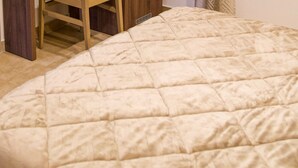 A bed with a quilted cover, a wooden nightstand, and a vent on the wall. - Room to dream (San Valentino Torio)