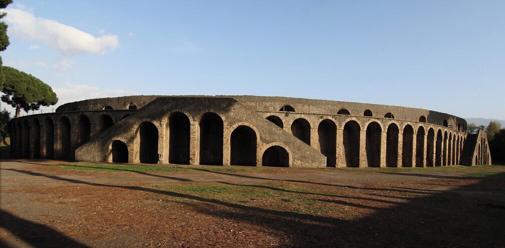 An ancient amphitheater with multiple arches and a circular layout.