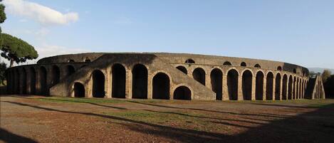 An ancient amphitheater with multiple arches and a circular layout.
