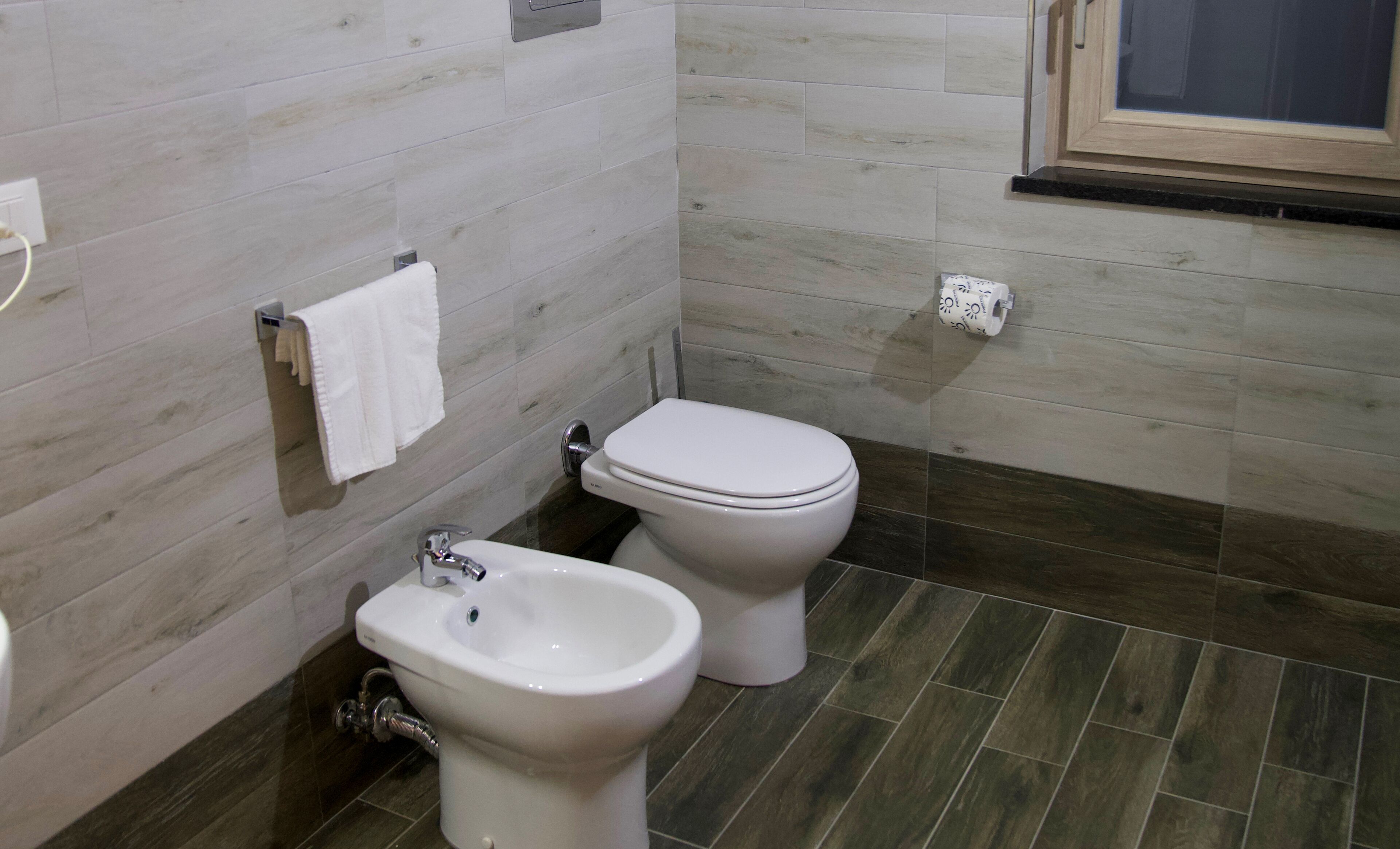A bathroom with a bidet, toilet, and sink.