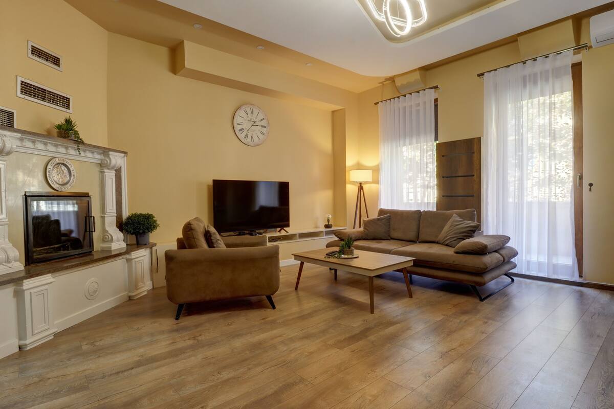 Een woonkamer met een open haard, een televisie, een bank en een salontafel.