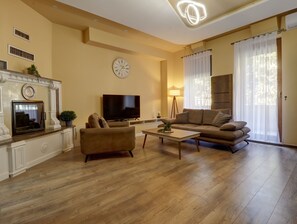 Suite, 1 très grand lit et 1 canapé-lit, balcon | Coin séjour | TV connectée