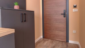 Een moderne keuken met een houten aanrecht, een donkerkoelkast en een houten deur.