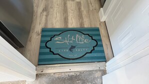 A wooden floor with a doormat that reads "Salt Life Live Salty."