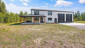 Une maison moderne à deux étages, dotée d’un porche abrité, d’un garage et d’une pelouse bien entretenue.
