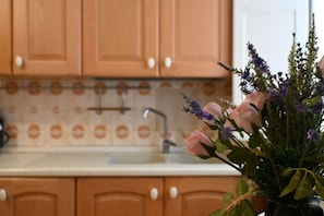 Una cocina con armarios de madera y salpicadero de azulejos.