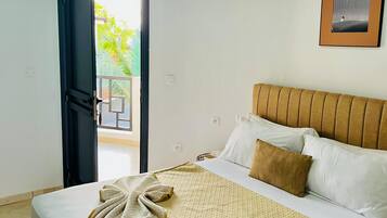 Un dormitorio con cama, una puerta que da a un espacio exterior y un cuadro en la pared.