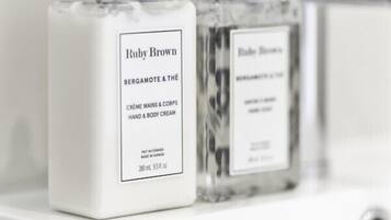 Due flaconi di crema corpo e mani Ruby Brown su una superficie bianca.