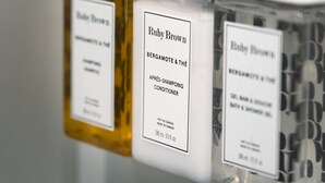 Ein Badezimmer mit drei Spendern für Ruby Brown Shampoo und Conditioner.