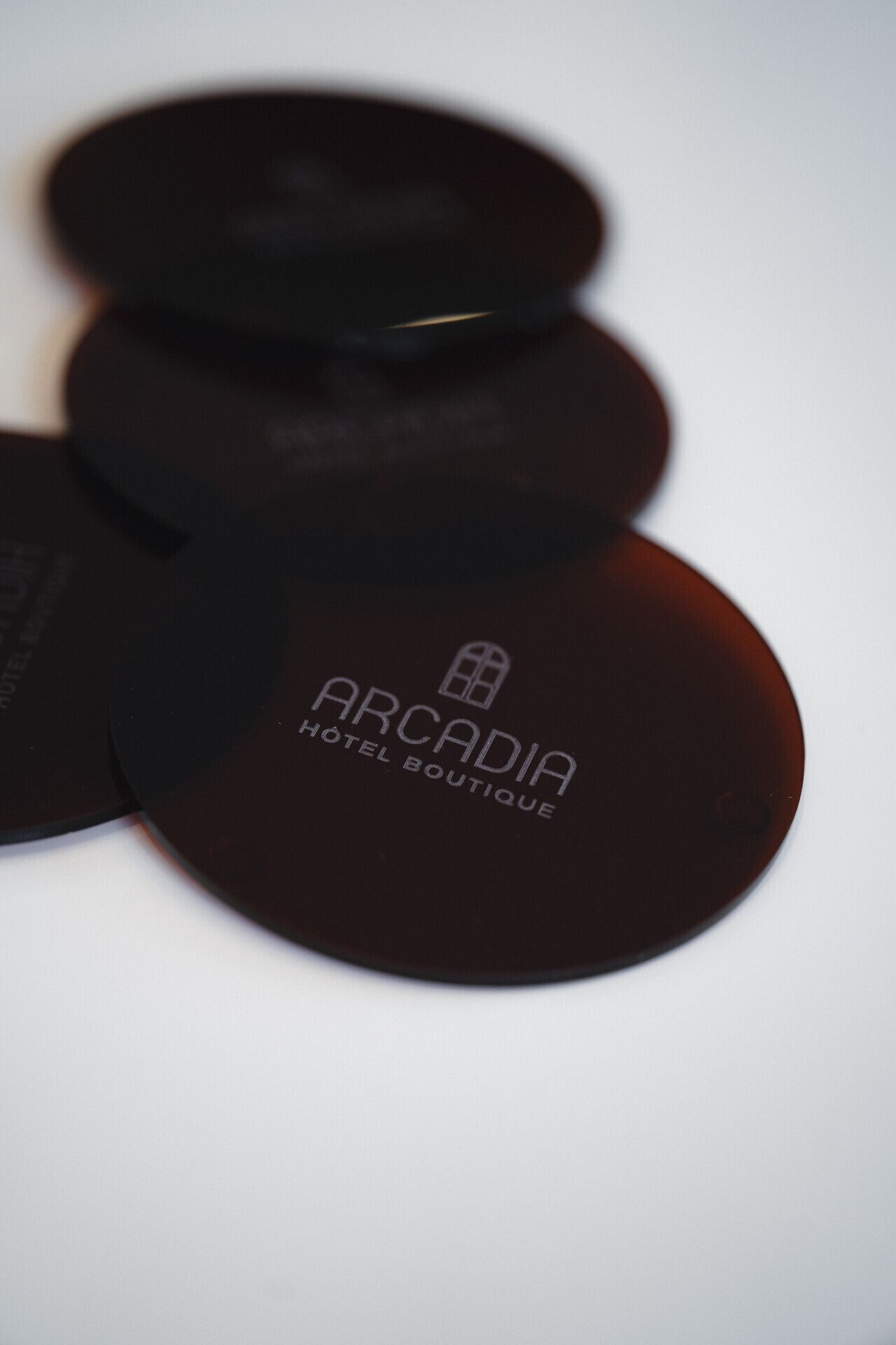 Uma pilha de objetos circulares com o texto 'ARCADIA HOTEL BOUTIQUE'.